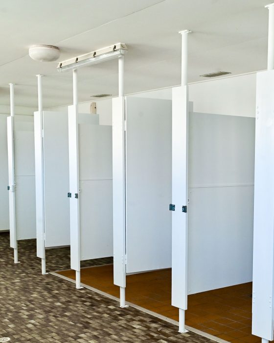 An interior shot of a clean but dated public shower or changing room.