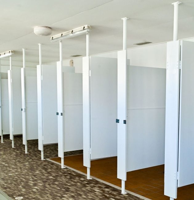 An interior shot of a clean but dated public shower or changing room.