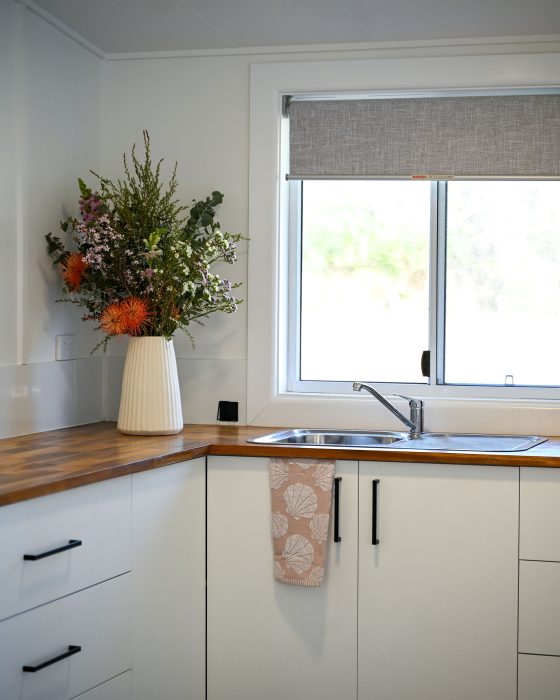 A close-up vertical shot of a bright, modern kitchen corner.